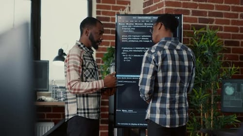 Equipe de programadores de software saindo após analisar o código-fonte na TV de tela de parede