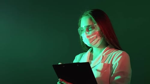 Woman Scientist Writes on Clipboard in Laboratory