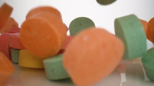 La caméra suit les smarties qui tombent à la surface. Ralenti.