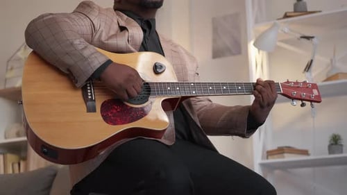 Man Plays Acoustic Guitar in Living Room