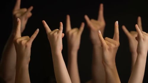 Raising Hands with Goat Gesture or Rock Sign