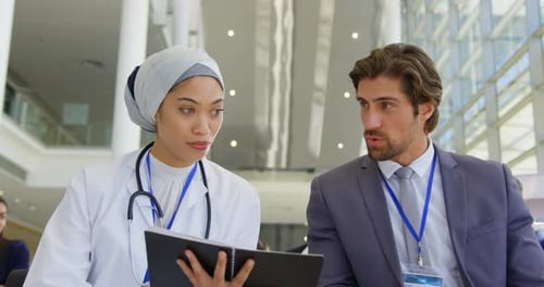 Female doctor discussing over digital tablet in the business seminar 4k