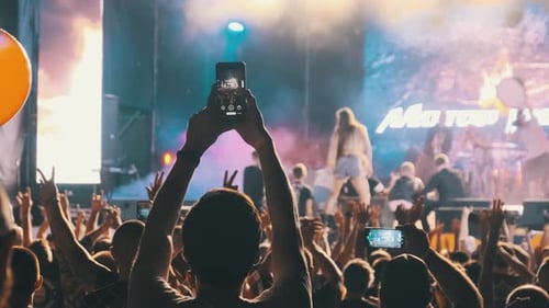Male with Smartphone in Hand Making Video at Live Rock Concert. Slow Motion