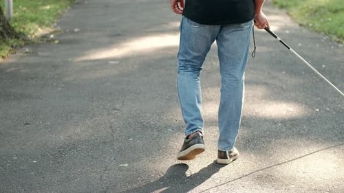 Junger blinder Mann geht im Park spazieren