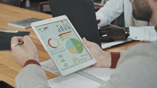 Business People Reviewing Data on Tablet