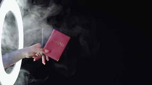 Woman's Hand Holding Passports to Ring Light