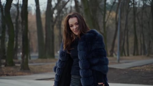 Stylish Woman in Fur Coat Posing in Urban Park