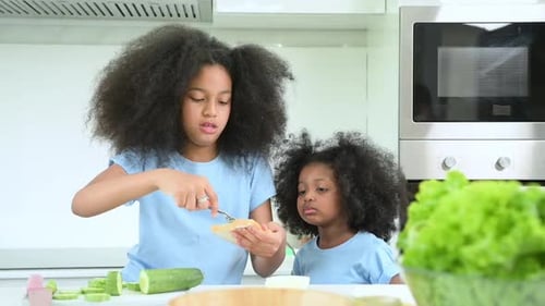 actividades de vacaciones familiares: dos hermanas cocinando la cena juntas en la cocina de la casa.