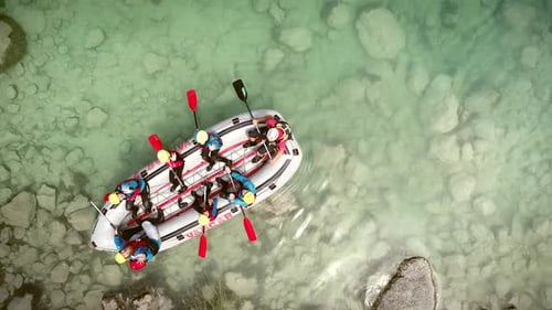 Luftaufnahme einer Gruppe beim Rafting im türkisfarbenen Wasser des Flusses Soca.