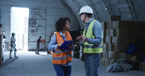 Warehouse Workers and Robot Consult on Tablet