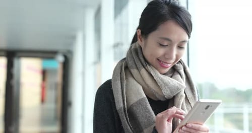 Une femme asiatique utilise un téléphone portable sur le campus universitaire