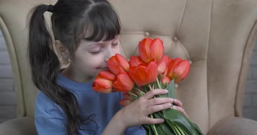 Young Girl Enjoys Bouquet of Orange Tulips