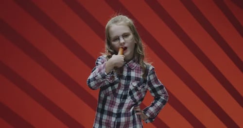 Girl with Blonde Hair Eats a Carrot
