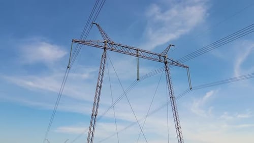 Transmission Tower with Power Lines Against Blue Sky