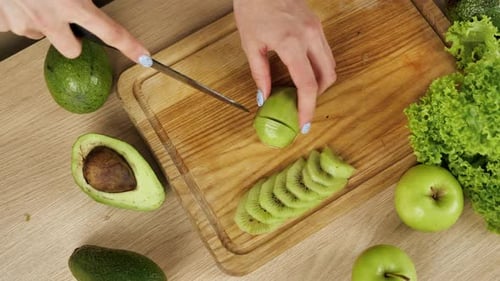 Womans schneiden frische grüne Kiwi