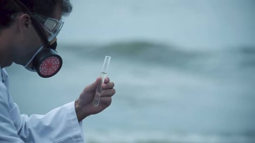 Scientist with Test Tube Near Murky Water