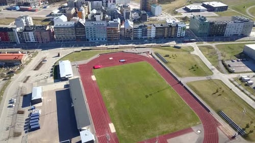 Aerial view of a soccer stadium with green grass in a city.