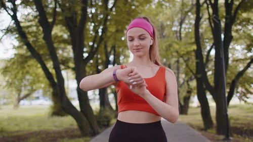 Woman Jogging in the Park, Checking Fitness Tracker