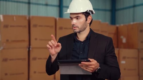 Factory Manager Using Tablet Computer in Warehouse or Factory