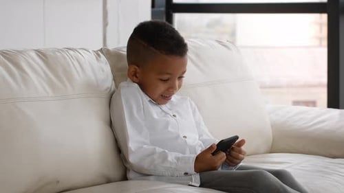 Young Boy Using Cell Phone on Couch