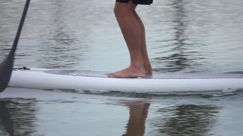 Extreme close up detail view of a man paddling his SUP stand-up paddleboard.