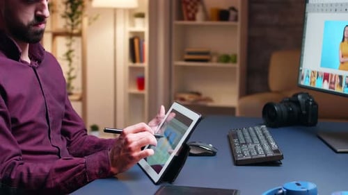 Man Editing Photos on Tablet in Home Office