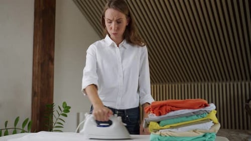 Woman Ironing Clothes on Ironing Board Indoors