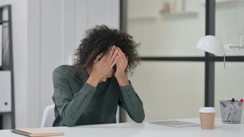 Stressed Woman Holding Head at Office Desk
