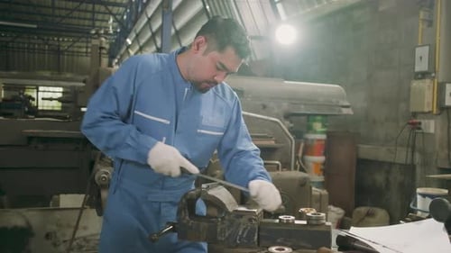 One professional Asian male worker works in metalwork manufacturing factory.