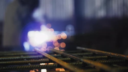 Worker Welding Steel Rebar with Sparks Flying