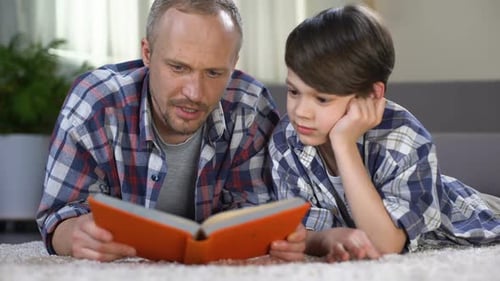Father and Son Reading Book Together Indoors