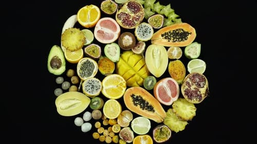 Rotating Exotic And Tropical Fruits On Black Background Top View.