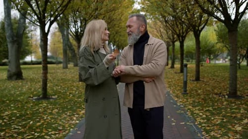 Smiling Couple of Lovers Having Fun with Active Hand Gesturing in Autumn Park