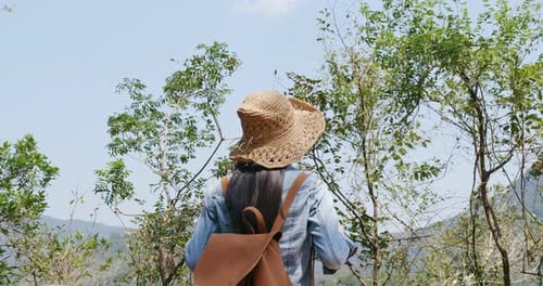 Woman With Backpack Hiking Through Tropical Scenery