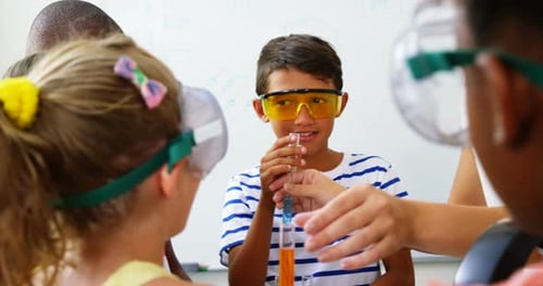 Children Conduct Science Experiment in Classroom with Teacher