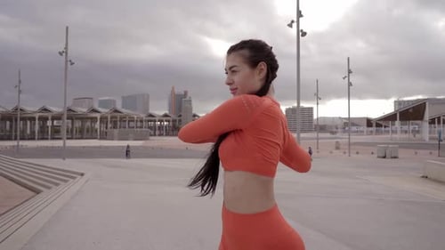 Young Woman Stretching Before Workout in City