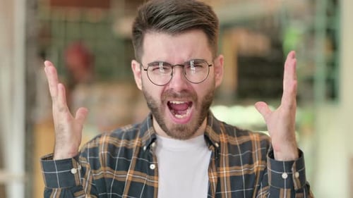 Young Man Shouting with Hands Raised