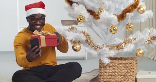 Man Video Calling with Christmas Gift