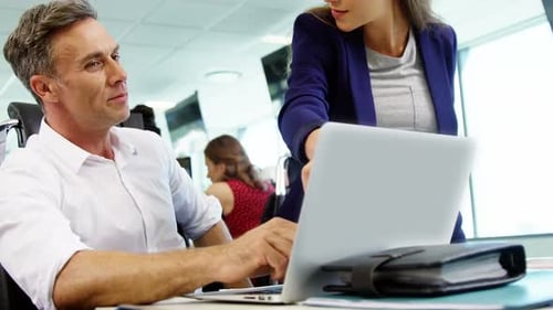 Executives discussing over laptop in office