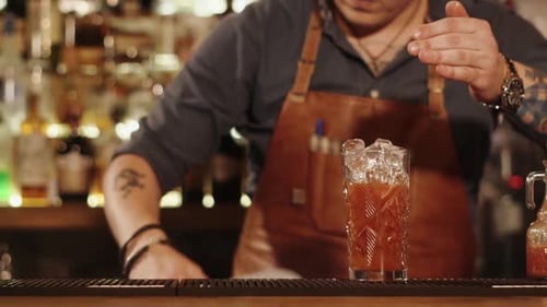 Nahaufnahme der Hände des Mannes, der das Eis in Gemüsesaft für den Besucher gibt