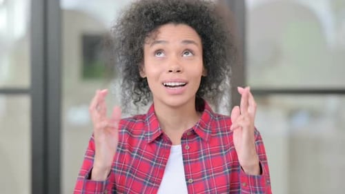 Young Woman Crossing Fingers Hoping for Luck