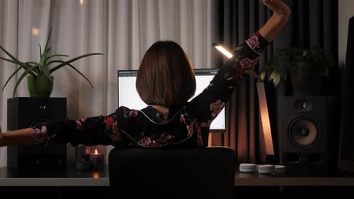 Mujer que trabaja desde casa en la computadora en la oficina en casa estirándose en el escritorio