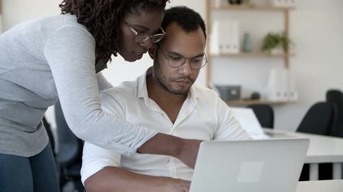 Team Collaborating on Laptop in Bright Workplace