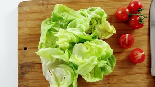 Fresh Lettuce and Tomatoes on Cutting Board