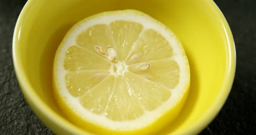 Juicy Lemon Half in a Yellow Bowl