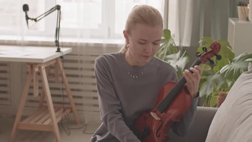 Young Woman Playing Violin in Living Room
