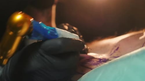 Tattoo Artist Inking Chest Piece With Tattoo Machine