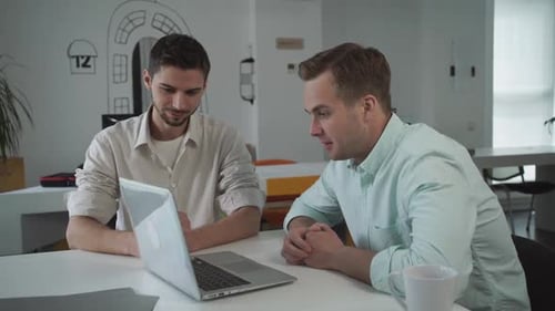 Young Adults Working Together at Table on Laptop