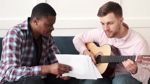 Guitar Player Practicing with Friend Indoors