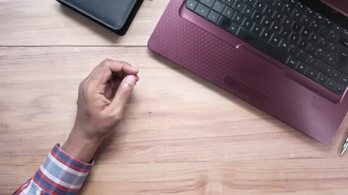 Draufsicht eines Mannes, der Tee trinkt und am Laptop arbeitet
